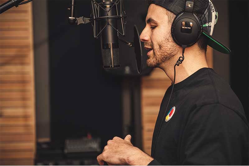 un chanteur avec un casque entrain d'enregistrer une chanson