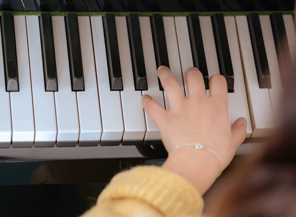 une main posée sur un clavier de piano