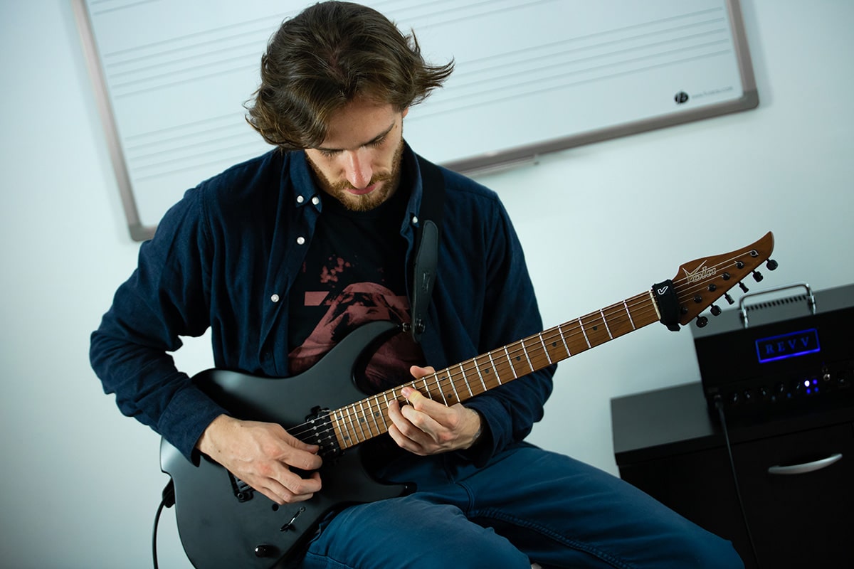 Photo-3 un professeur montre comment tenir ses doigts sur un manche de guitare