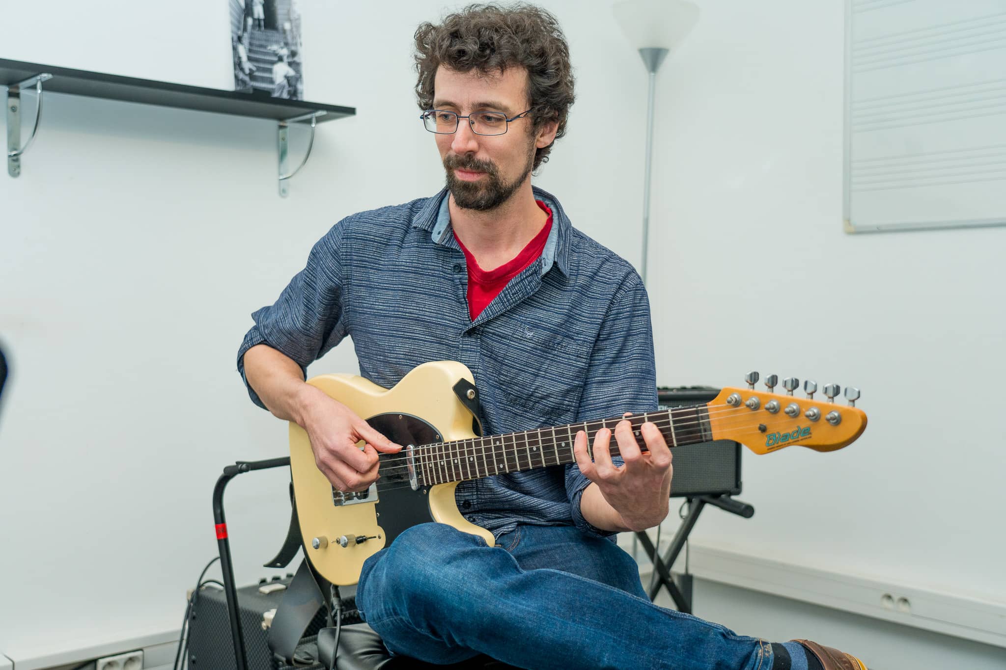 photographie du professeur de guitare indiquant où placer ses doigts sur le manche